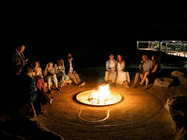 Guests gather around a fire pit at Wilderluxe Lake Keepit
