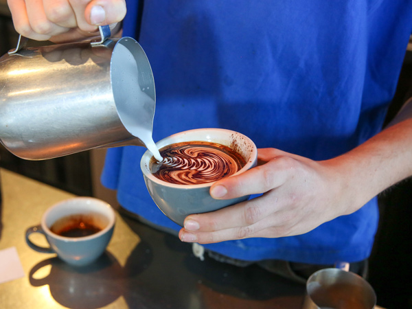 pouring milk over coffee at HAM Cafe, Sydney