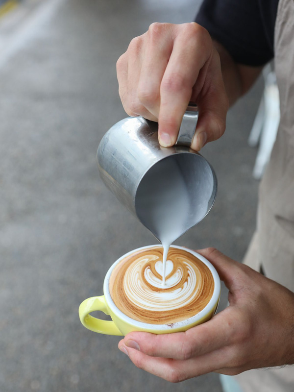 pouring milk over coffee at Up South Bondi, Sydney