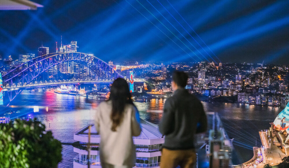 A couple watching the lights of Vivid Sydney at Aster, InterContinental Sydney