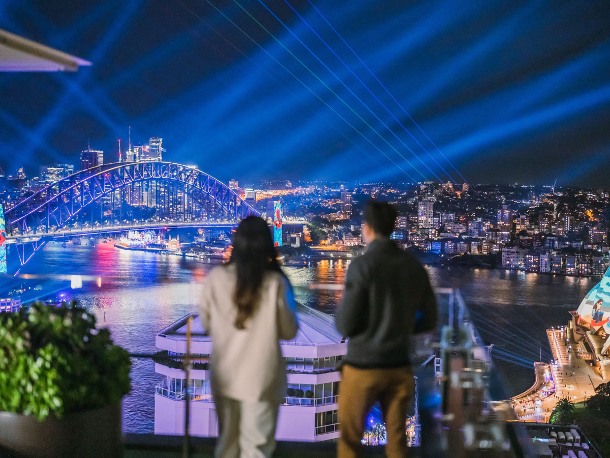 A couple watching the lights of Vivid Sydney at Aster, InterContinental Sydney
