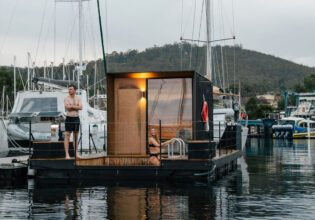 A man and woman standing on a floating sauna.
