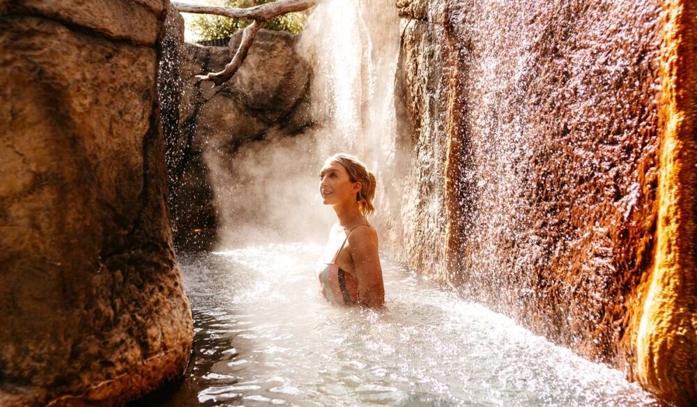 a woman soaking in an outdoor hot spring at Deep Blue Hotel