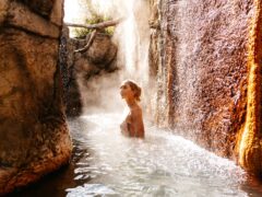 a woman soaking in an outdoor hot spring at Deep Blue Hotel