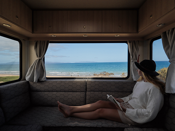 A woman sitting while reading inside Star RV Motorhomes spacious Polaris 6.
