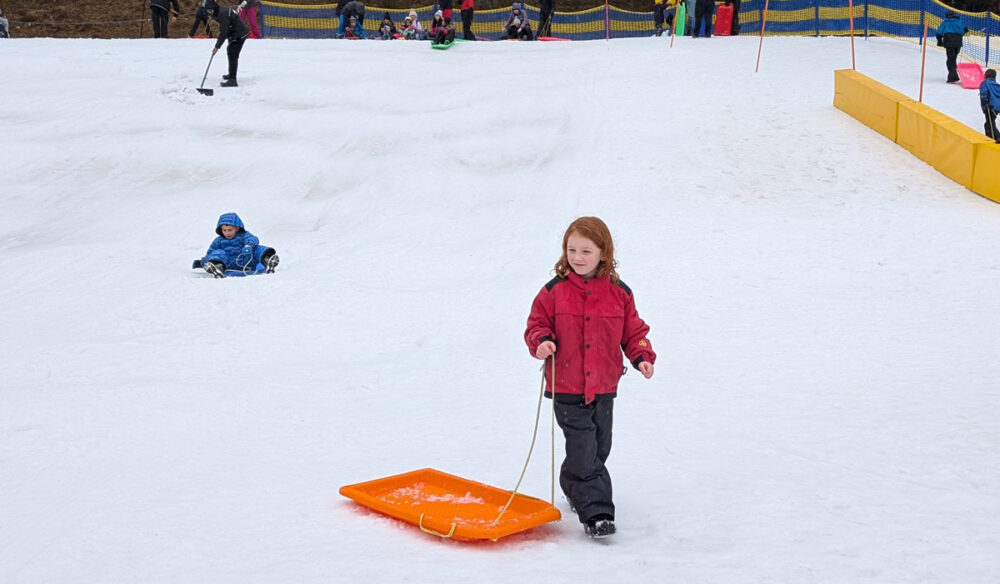 Young girl at Corin Forest with toboggan