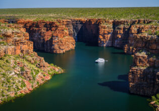 A Kimberley cruise drifts beneath King George Falls, where sheer sandstone cliffs frame the thunderous plunge into turquoise waters. Discover the best of Australia's North West cruises.