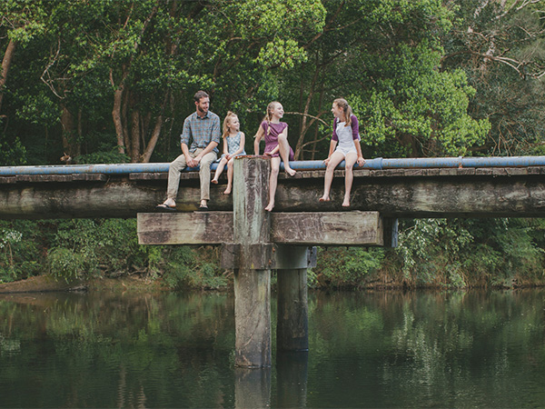 A family sitting by the Orara Valley Tourist Trail.