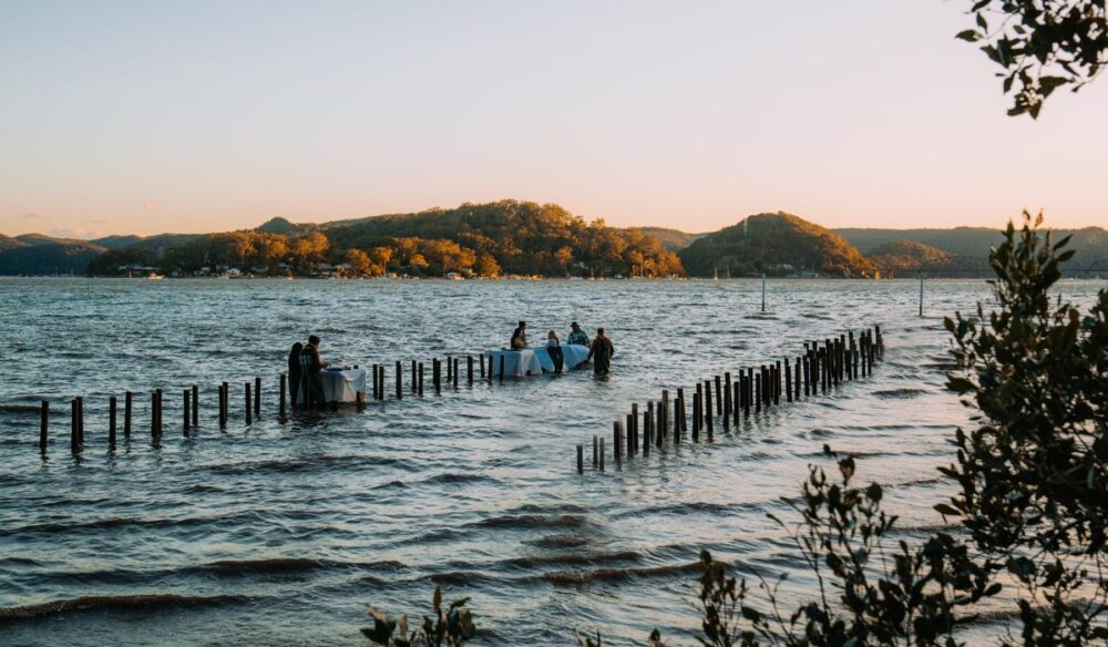 People wading in the water at Sydney Rock Oysters in-water dining experience