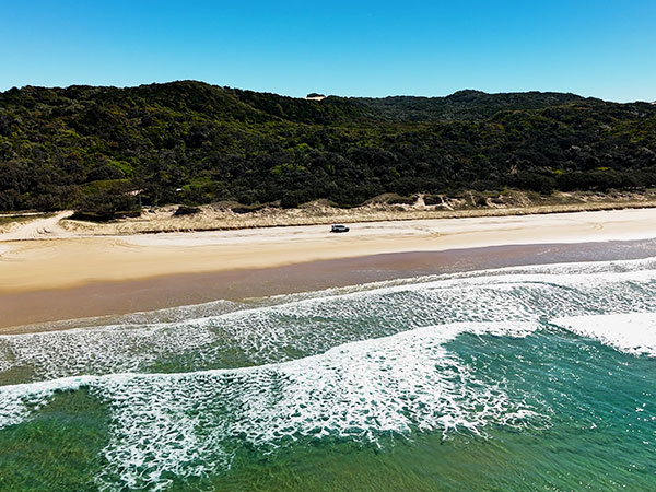 car driving along 75 mile beach on k'gari