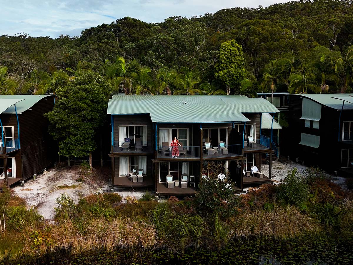 kassia standing on resort room balcony at kingfisher bay resort on k'gari
