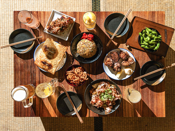 a spread of Japanese dishes and cocktails on the table at Nakano Darling