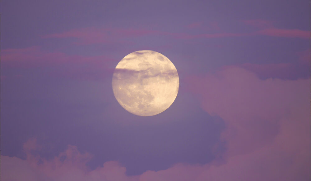 A full moon during sunset